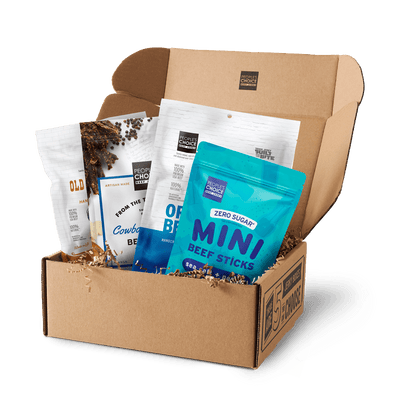 Branded box with assortment of beef jerky bags in it while against a transparent background. 
