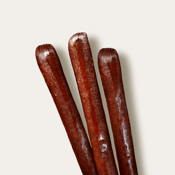 Three beef sticks on a white background. 
