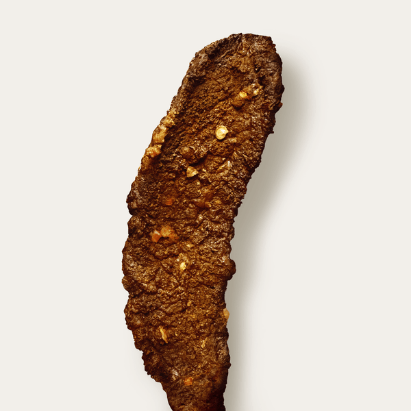 Free floating piece of Hatch Green Chile Beef Jerky on a white background