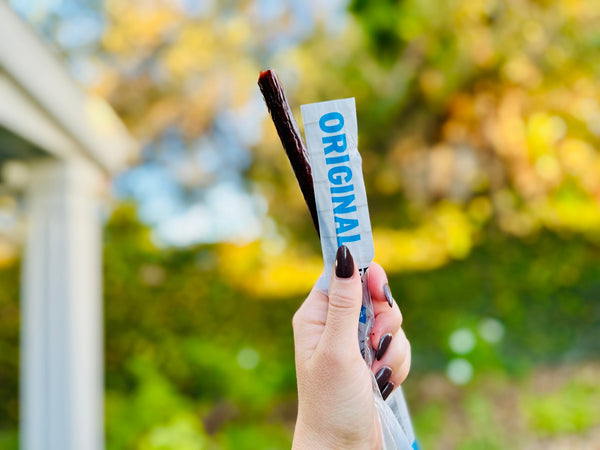 Woman holding beef stick. 
