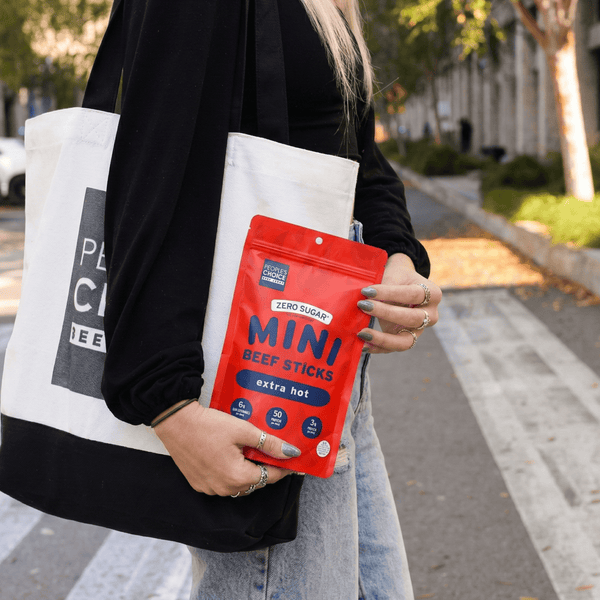 Person holding extra hot flavored mini beef sticks on a street