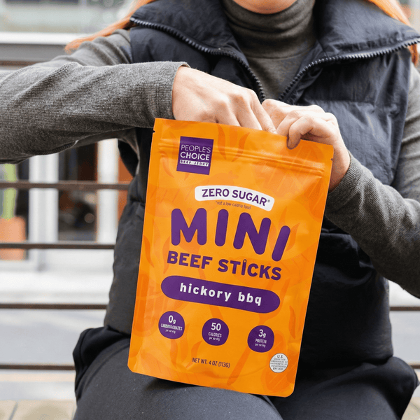Person holding a package of Zero Sugar Mini Beef Sticks in hickory BBQ flavor