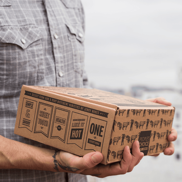 Man holding a closed jerky box. 
