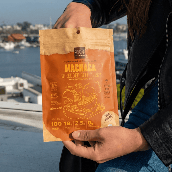 Person holding a package of Machaca beef jerky by the waterfront