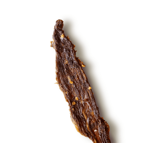 Close-up of a textured, beef jerky piece on a transparent background