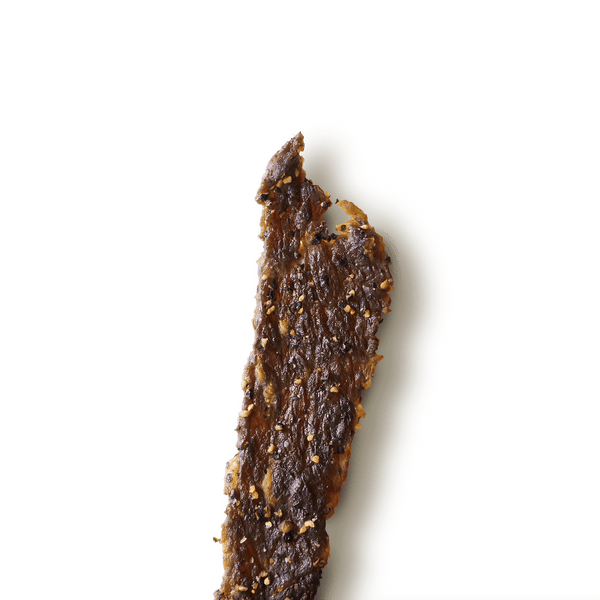 Close-up of a textured, beef jerky piece on a transparent background