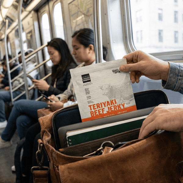 Person on a subway holding a bag of Teriyaki Beef Jerky