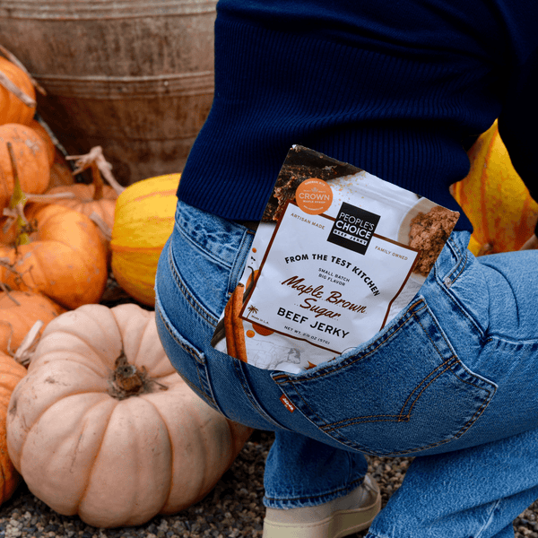 A package of Maple Brown Sugar beef jerky in a woman's back pocket at a pumpkin patch. 